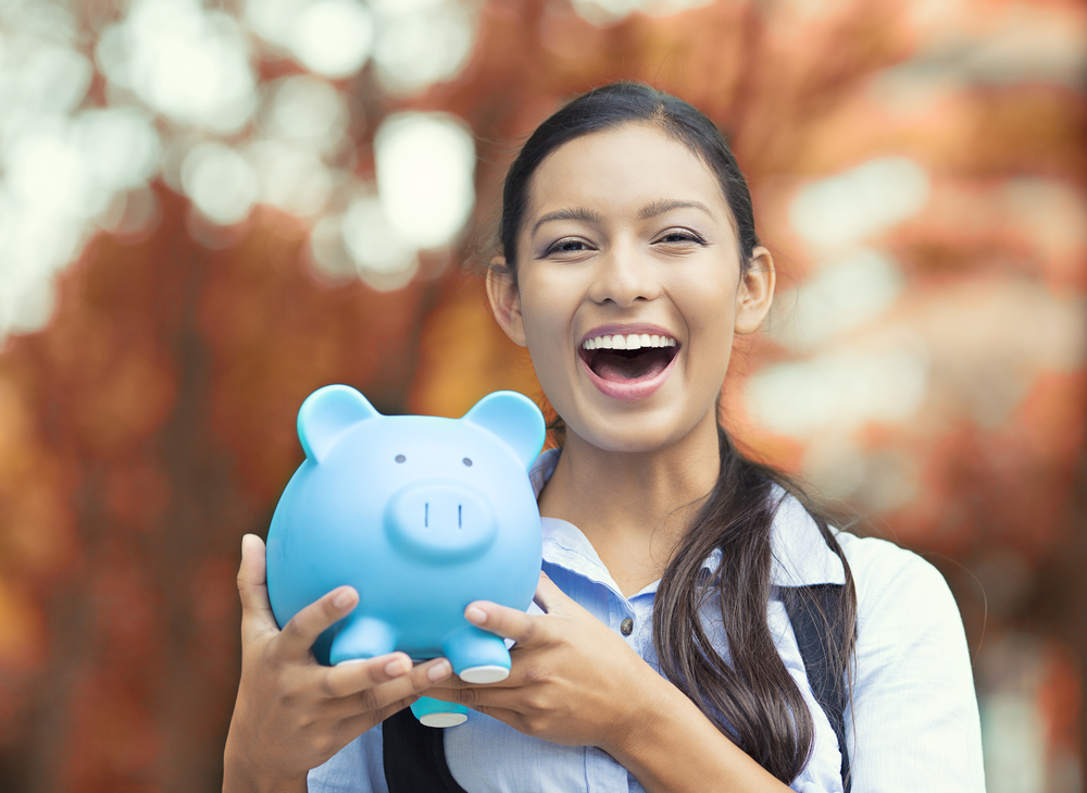 Closeup portrait happy, smiling business woman, bank employee holding piggy bank, isolated outdoors indian autumn background. Financial savings, banking concept. Positive emotions, face expressions-3